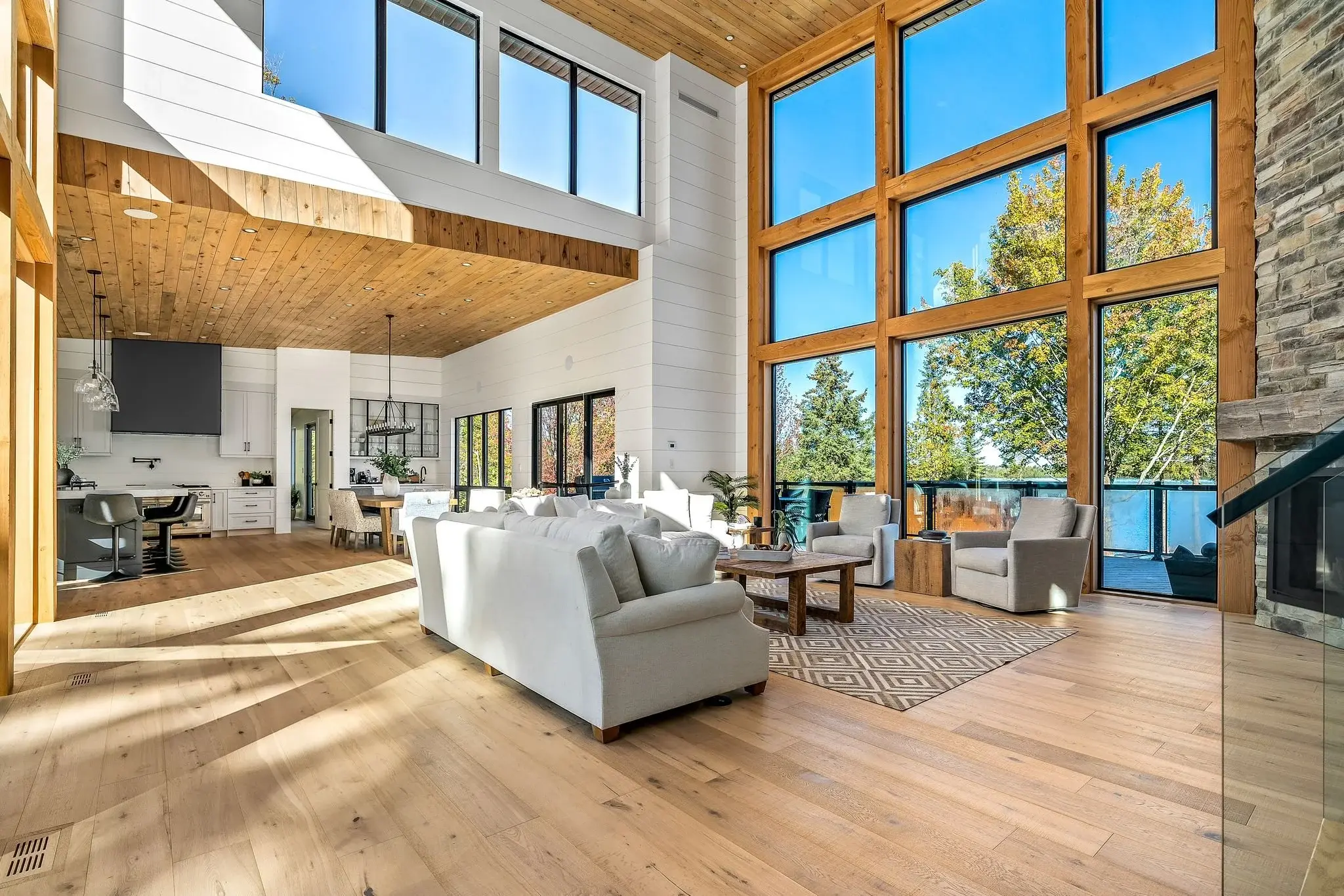 The View on Balsam: double-height great room with cathedral wood ceiling and full-height lake windows
