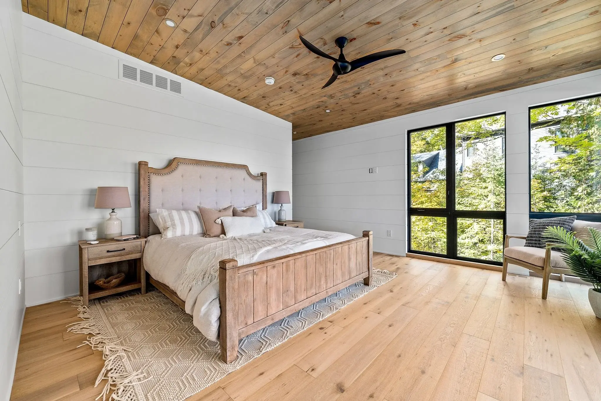 The View on Balsam: primary bedroom with upholstered wood bed and forest views
